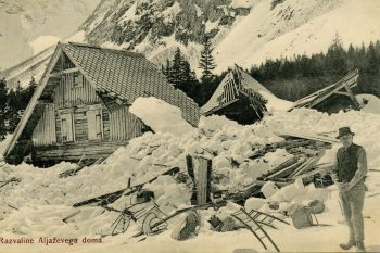 Aljažev dom, ki so ga na Vratih postavili leta 1904, je pet let pozneje podrl snežni plaz. Med ostanki ostrešja doma je sliki Janez Klinar – Požganc, gorski vodnik iz Mojstrane. Kot izkušen delovodja je bil nenadomestljiv sodelavec pri Aljaževih gradnjah v triglavskem pogorju: prvotni Aljažev in Triglavski dom, Staničevo zavetišče, Tominškova pot, pot čez Prag in na Mali Triglav ter izstrelitev nevarnih mest na grebenu med obema vrhovoma. (Foto: Bogumil Brinšek (1884-1914)