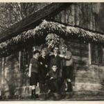 Družina Dobrina pred domačo leseno hišo.