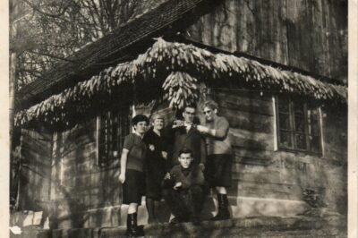 Družina Dobrina pred domačo leseno hišo.
