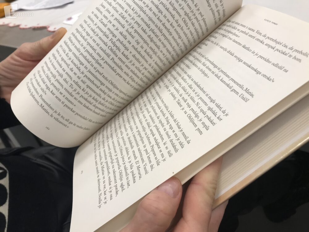 Knjigosnedka drži v roki knjigo in jo bere.