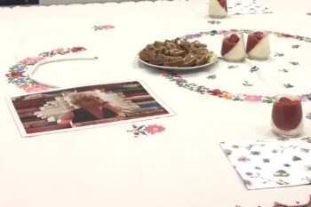Praznično pogrnjena miza s pecivom in sladico.